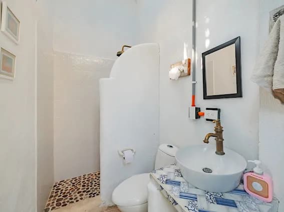 Baño blanco con ducha abierta