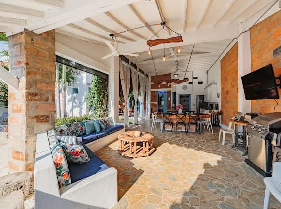 Patio BBQ con sofás, comedor, parrilla y luces