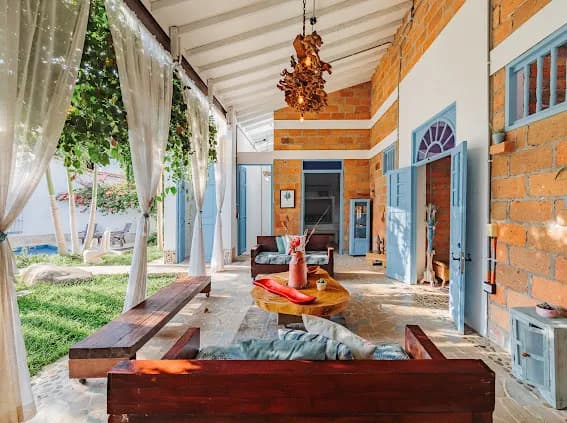 Terraza cubierta con sofás de madera y vista al jardín